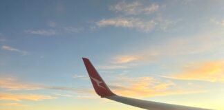 The Hidden Benefits of Flying Indirect airplane wing over puffy clouds at sunset
