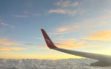The Hidden Benefits of Flying Indirect airplane wing over puffy clouds at sunset