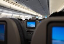 Who picks the movies you watch at 35,000ft? interior of a passenger plane with screens on the backs of the seats
